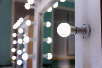 Empty woman makeup place with mirror and bulbs. Workplace makeup artist in modern makeup room. Barbershop interior. Dressing room with makeup mirror and table. Modern classical style interior design.