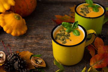 Autumn pumpkin soup with pumpkin seeds in a tin cup, Thanksgiving