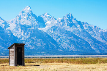 Old abandoned wooden outhouse at Mormon Row Historic District in scenic Antelope Flats valley area....