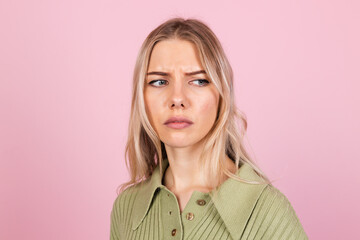 Pretty european woman in casual sweater on pink background suffering unhappy  with gloomy...