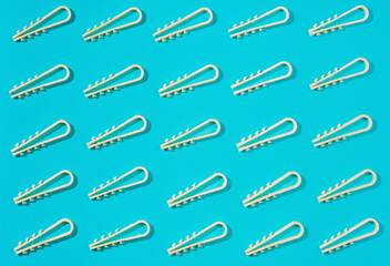 Layout plastic fixings for electrical cables or pipes on walls and ceilings during the installation of electrical wires. Clamps laid out on bright blue background, top view with copy space