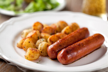 Sausages and potatoes on a plate. High quality photo.