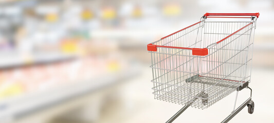 empty red shopping cart in supermarket aisle