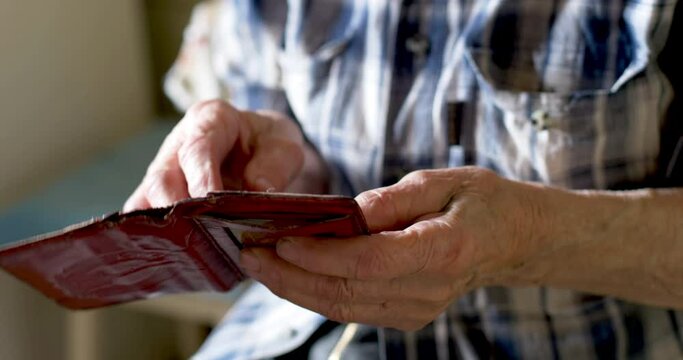old man counts the money in your wallet