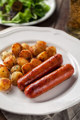 Sausages and potatoes on a plate. High quality photo.