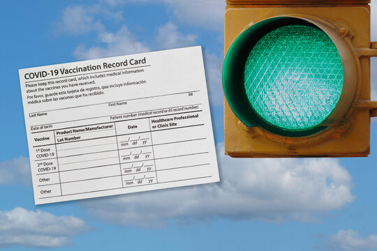 Photo Collage Of A Covid-19 Vaccination Record Card And A Green Traffic Light Against A Sky, Representing Activities Opening Being Allowed As More People Get Vaccinated