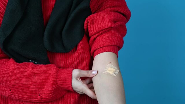 A woman showing her arm with an adhesive bandage after injection after blood donation or tests. Medical, pharmacy, and healthcare concept. High quality 4k footage