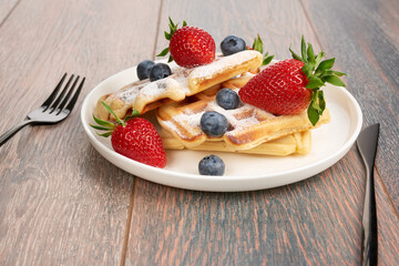 Belgian waffles with strawberries and blueberries.