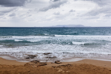 Fototapeta na wymiar Sea with waves and a sailboat on the horizon he beach with 