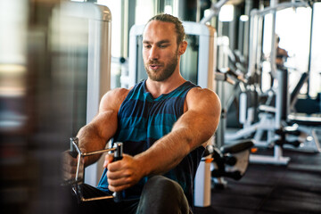 Fit man exercising at the gym on a machine