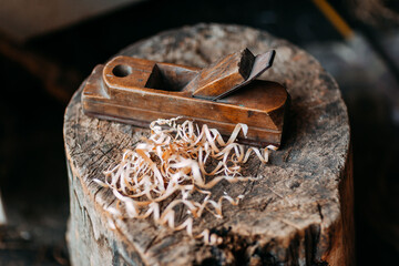 Old wooden jack plane with curly shavings. Wood shavings on old stump. Fresh curly sawdust. Wooden curls.