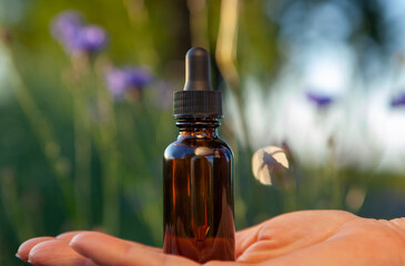 Female holding a dropper bottle of essential oil. Flower therapy - BACH.