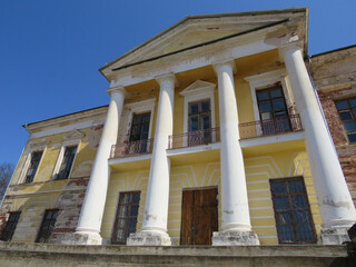 An old abandoned building with columns on a sunny day.