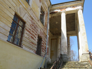 An old abandoned building with columns on a sunny day.