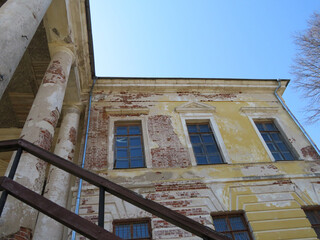 An old abandoned building with columns on a sunny day.