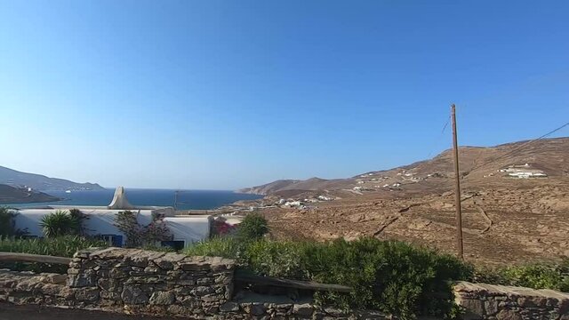 slow motion ocean view by the road on a motorbike and quad in mykonos greece during the summer season
