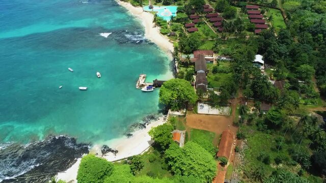 Aerial drone view overlooking a resort on the coast of sunny, Ilheu das Rolas,