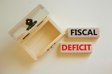 Fiscal deficit symbol. Concept words 'fiscal deficit' on blocks on a beautiful white background, small empthy chest. Business and fiscal deficit concept, copy space.
