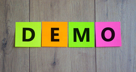 Demo symbol. Concept word 'demo' on colored papers on a beautiful wooden background. Business and...
