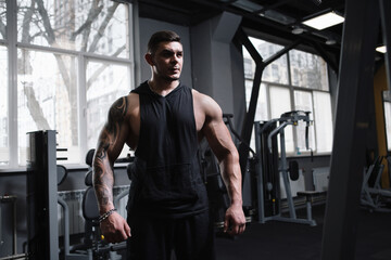 Fototapeta na wymiar Muscular professional bodybuilder at the gym, copy space