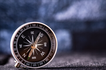 Fototapeta na wymiar Travel planning navigation concept. Classic magnetic detail of black compass on light blue backround
