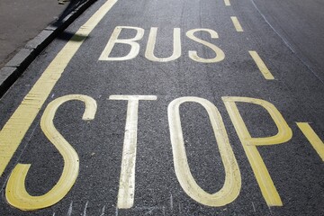 Fototapeta premium Freshly applied bus stop road paint on recently resurfaced street