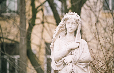 White sculpture of a woman in a park