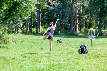Young woman playing flying disc sport game in the park