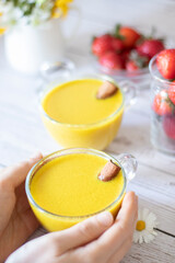 Golden dairy-free latte with turmeric powder, cinnamon, ginger, and spices. A cup of warm creamy winter healing drink. Healthy food concept.