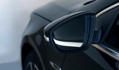 Close-up of the side left mirror and window of the car body black SUV on the street parking after...