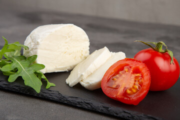 Mozzarella, tomatoes and fresh salad. Concrete grey background.