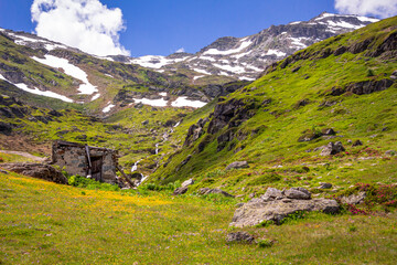 Old abandoned hut, near the waterfall, on the peaks of Valgrisenche. Aosta valley. Italy