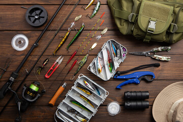 Fishing tackle - fishing spinning rod, hooks and lures on wooden background. Active hobby...