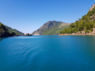 Obraz premium Seascape against the backdrop of mountains on a cloudless sunny day.