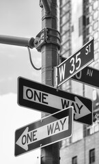 Black and white picture of One Way road signs at West 35th Street in New York City, USA.