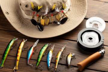 Fishing tackle - fishing spinning rod, hooks and lures on wooden background. Active hobby...