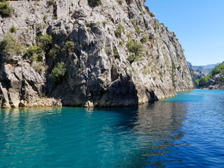 Seascape against the backdrop of mountains on a cloudless sunny day.