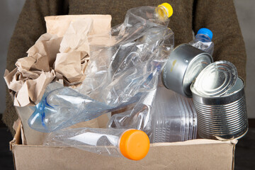 Recycling and ecology concept. Sorting household waste - plastic, paper, metal. Grey concrete...