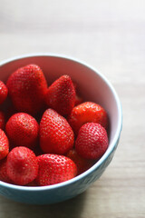 Bowl of fresh strawberries on a table. Selective focus.