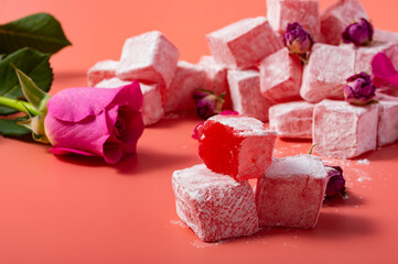 Levitating rose flavored pink Turkish delight with flower petals and dry rose buds