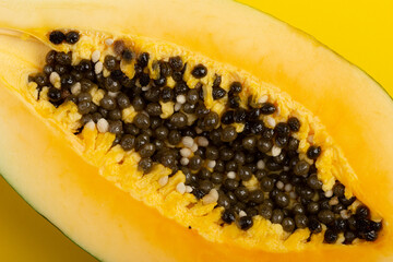 Ripe papaya close-up on yellow background. Fresh fruits and vegetables healthy food