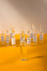 Many ampoules with medicine yellow-gray background, bright light. Medicine concept