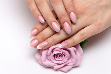Wedding French white, silver manicure on long oval nails with a pink rose in hands - obrazy, fototapety, plakaty