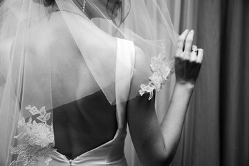 colorless photo. The bride prepares for the wedding and puts on the veil
