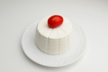 Top view of fresh ricotta cheese with cherry tomatoes on white background italian food concept. Still life.Typical Sicilian salted ricotta cheese On white background.