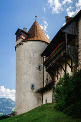 Fototapeta premium External view of the village of Gruyeres, famous cheese making town of switzerland. Detail ot its medieval castle with cloudy background