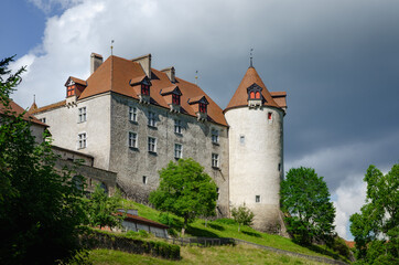 Fototapeta premium External view of the village of Gruyeres, famous cheese making town of switzerland. Detail ot its medieval castle with cloudy background