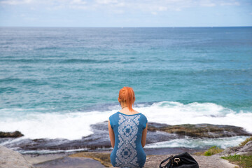 a woman sitting facing the bay in sydnay australia