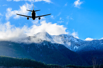 Naklejka na ściany i meble flight of the airplane (jet) over beautiful sky and snow mountains