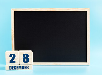 December 28th. Day 28 of month, Cube calendar with date, empty frame on light blue background. Place for your text. Winter month, day of the year concept